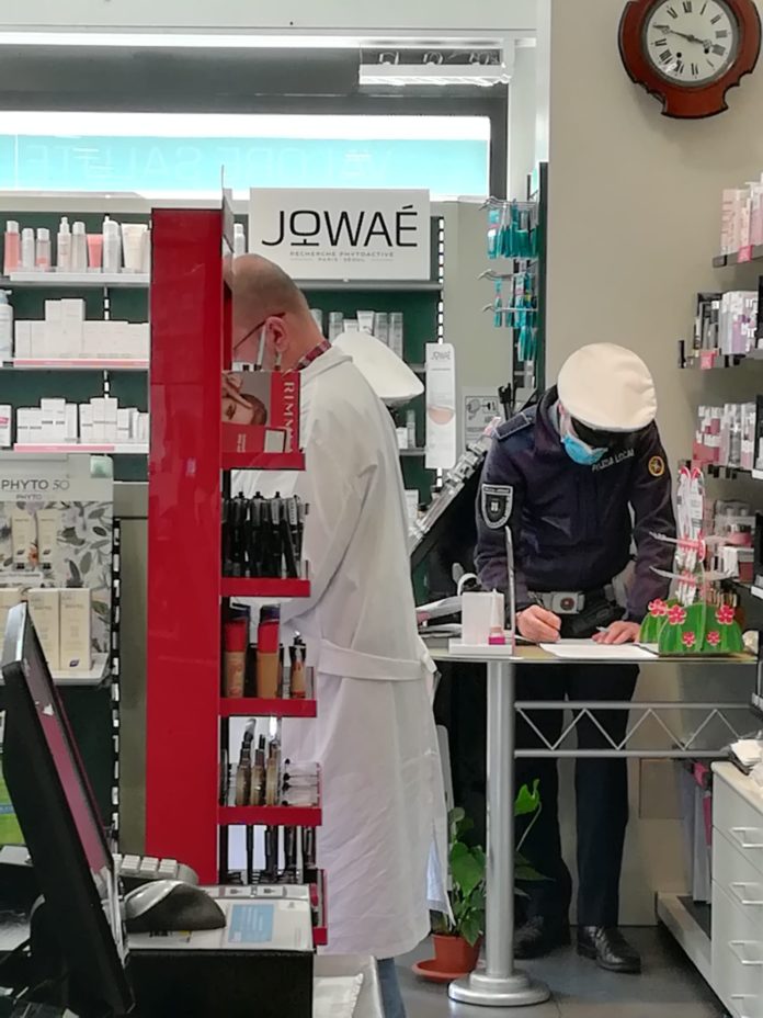 agente che notifica la multa al malcapitato farmacista